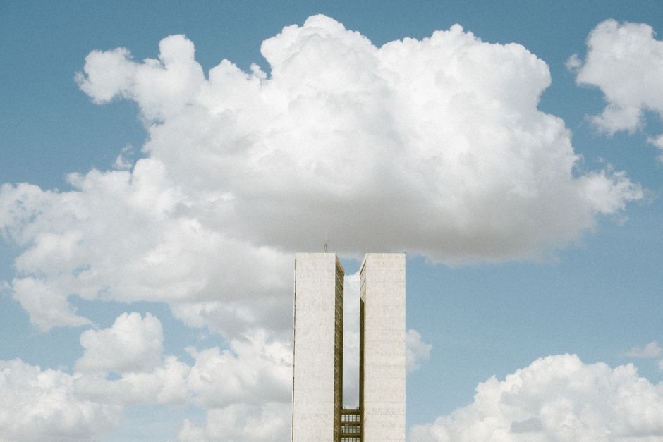 Concursos Brasília — View of the National Congress in Brasília with impressive cloud formations in the sky.